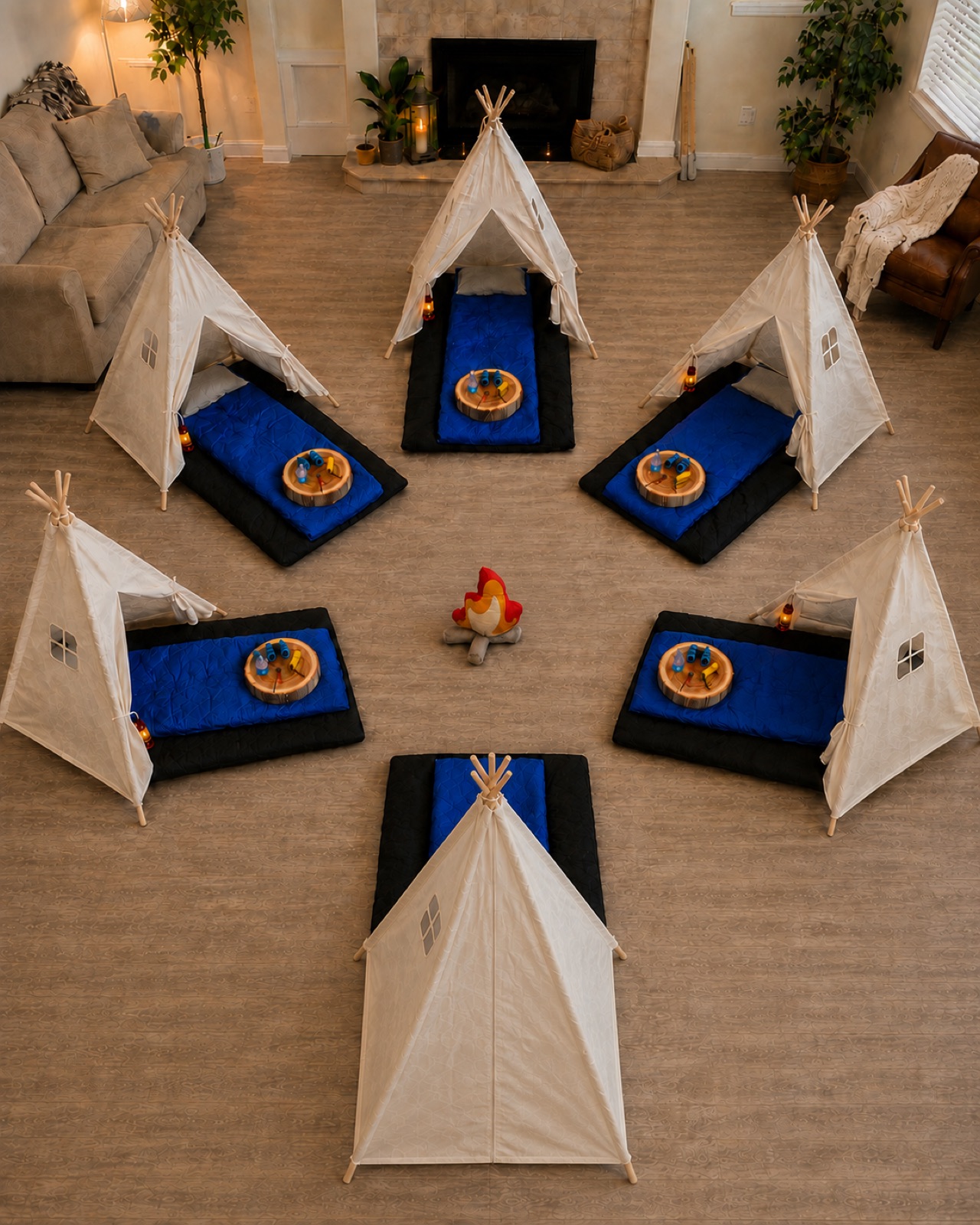 Six Base Camp teepees in a circle around a cloth campfire, seen from above
